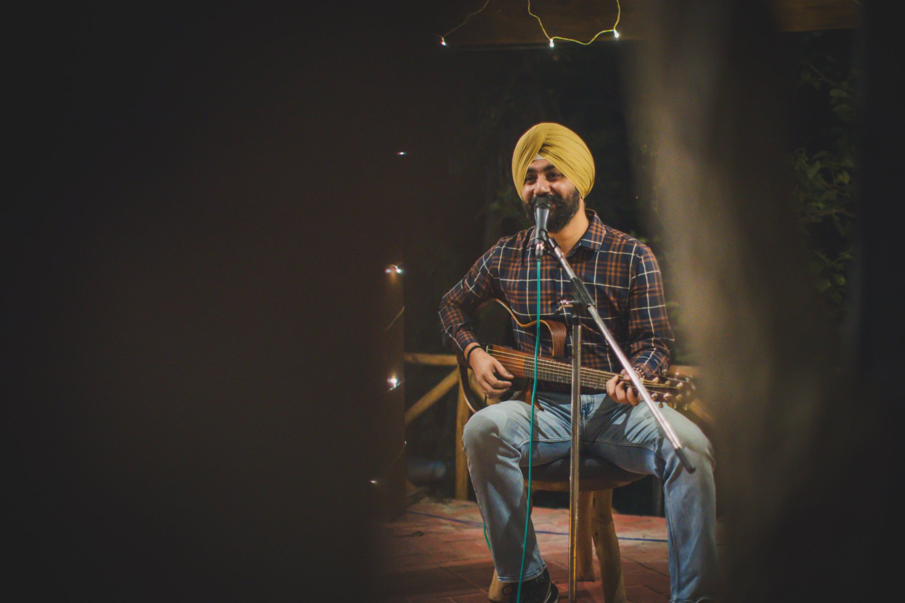Guitarist singing into a microphone during the evening music programme at Auramah Festival 2026.
