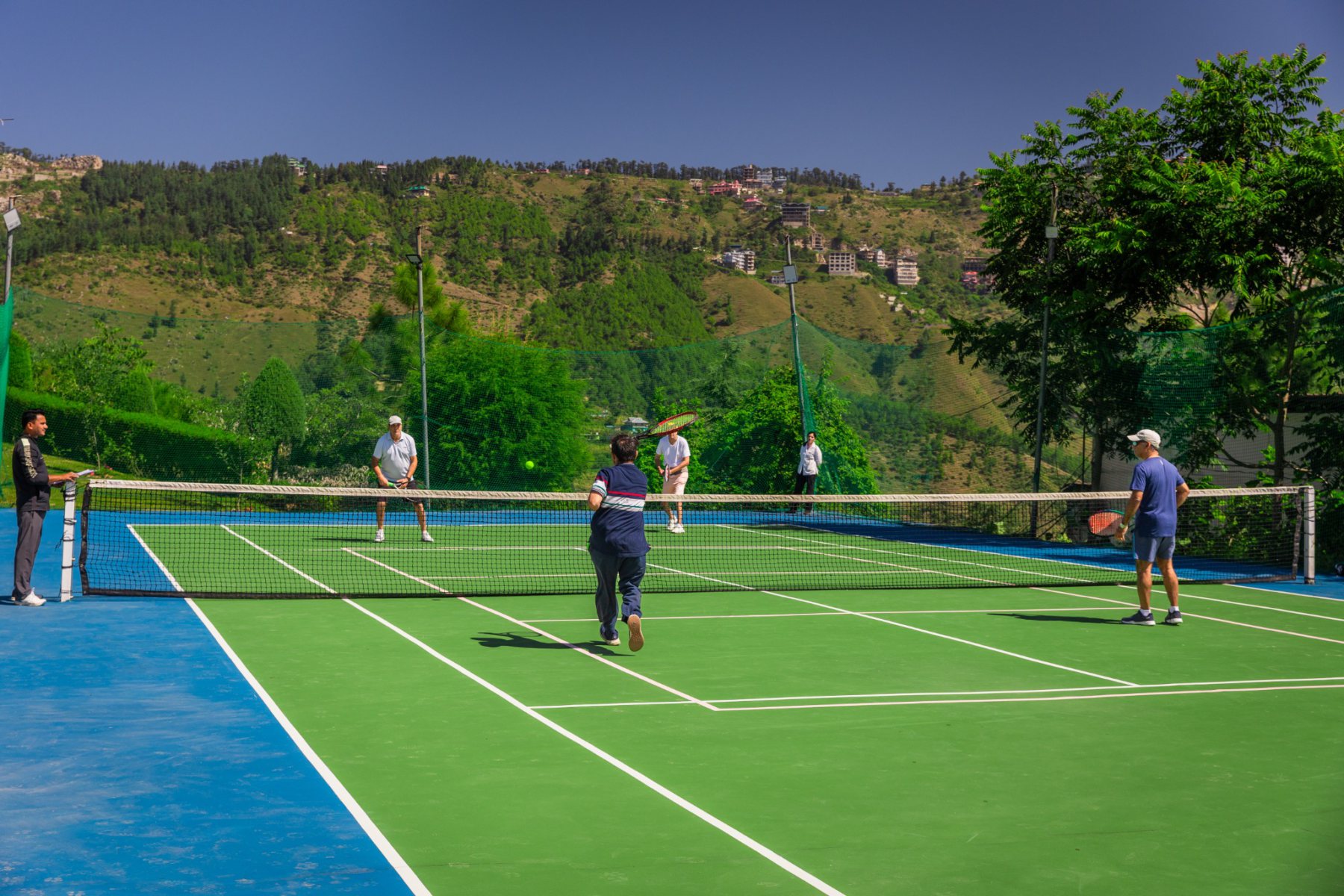 Players competing in the tennis tournament on the outdoor court at Auramah Valley during Festival 2026