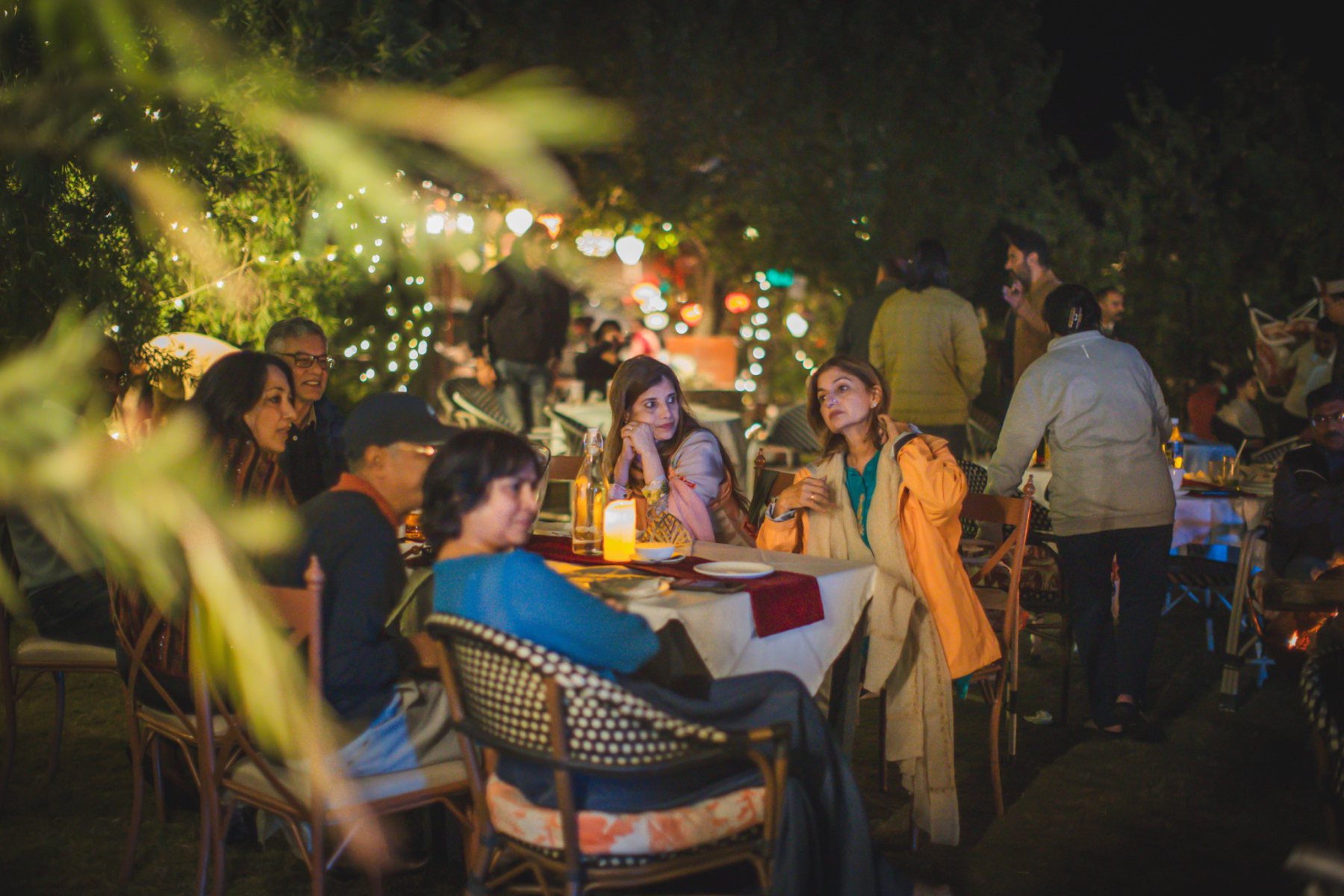 Guests seated at an outdoor evening dinner gathering at Auramah Valley.